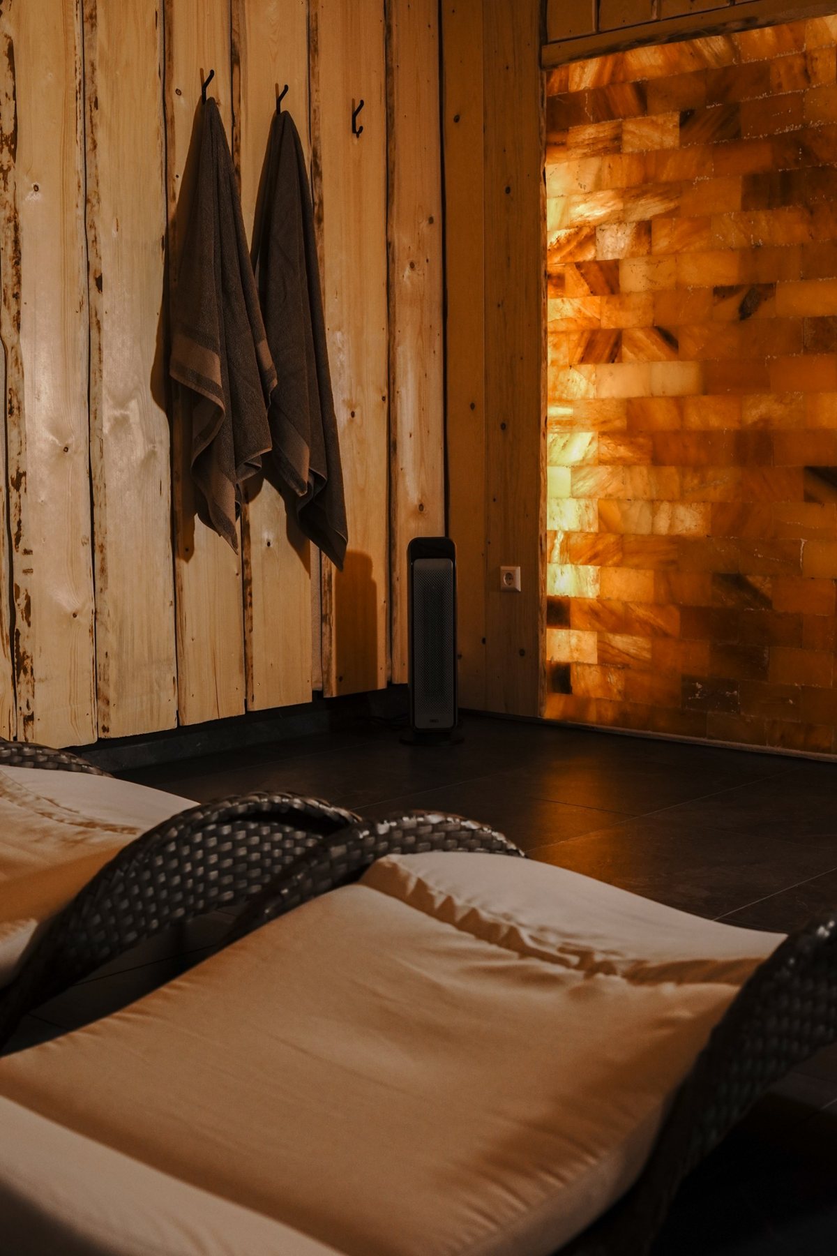 Ruheraum mit Liegen und warm beleuchteter Salzsteinwand